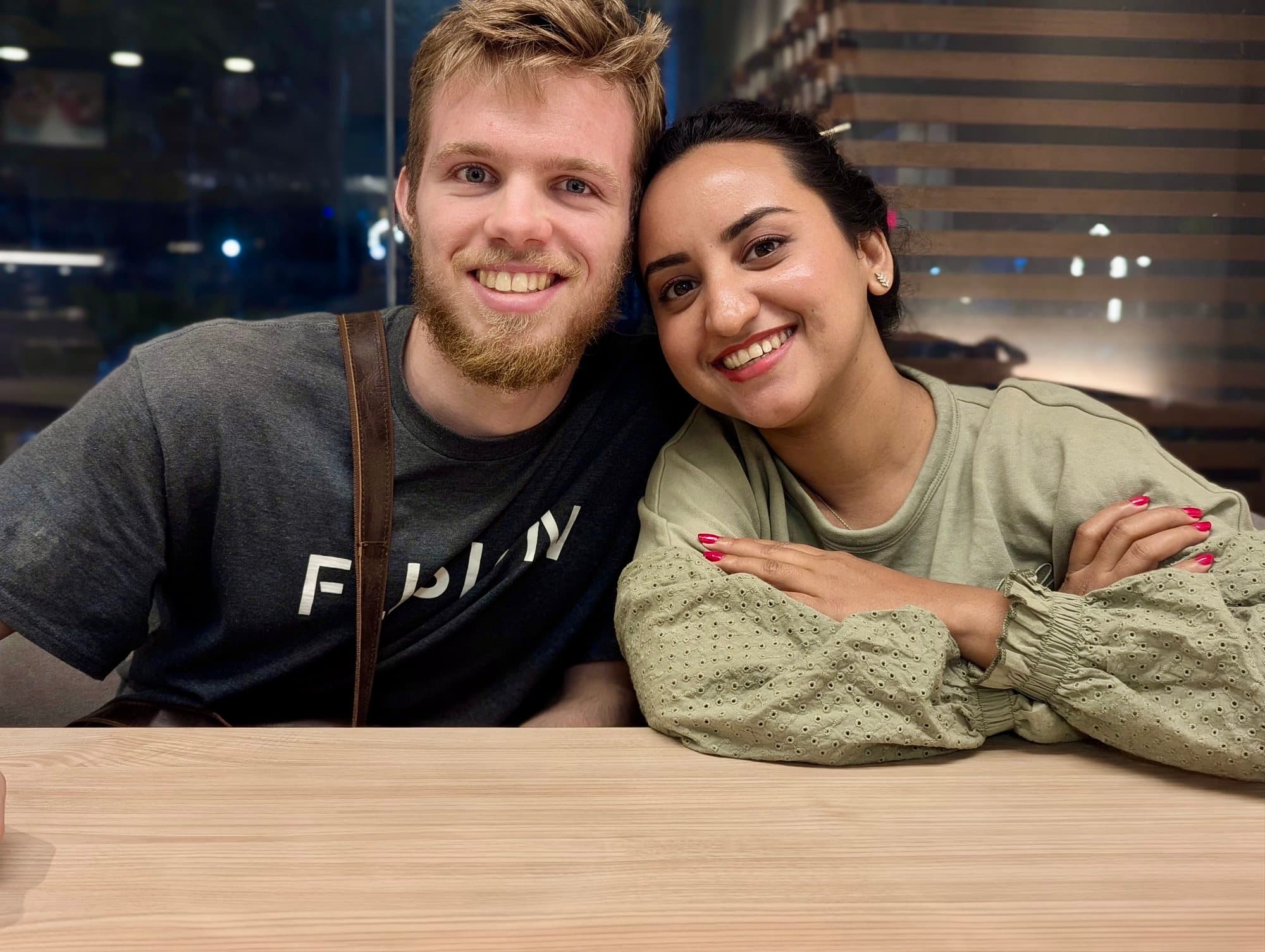 Thomas and his wife Monisha, smiling side by side at a table